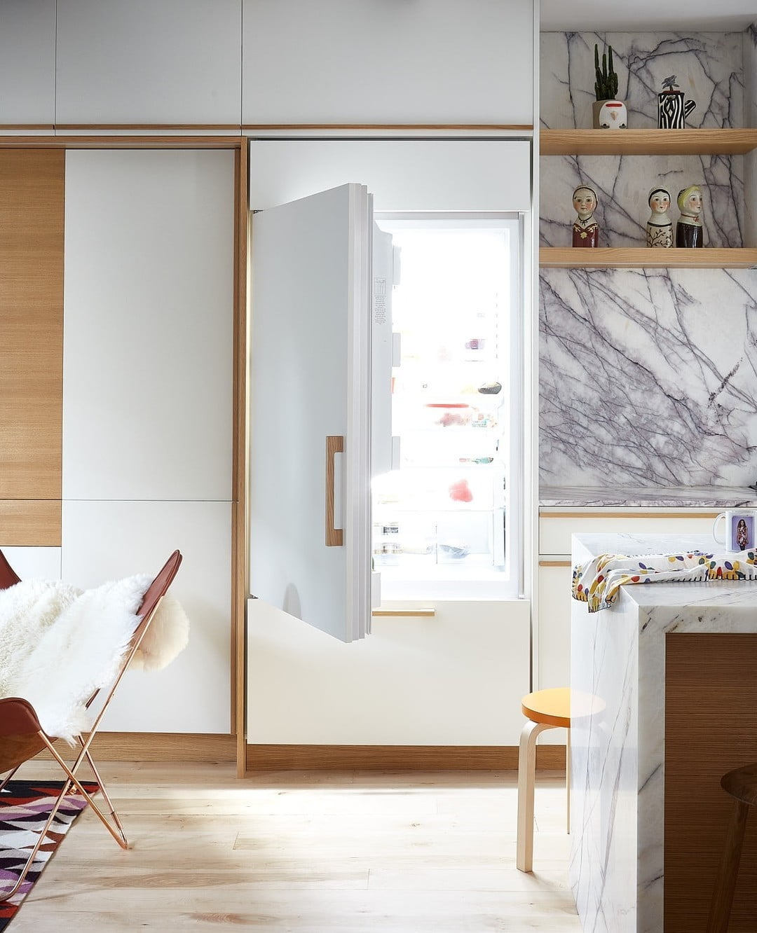 A panel-ready refrigerator integrated seamlessly into the cabinetry of a modern, well-lit kitchen.