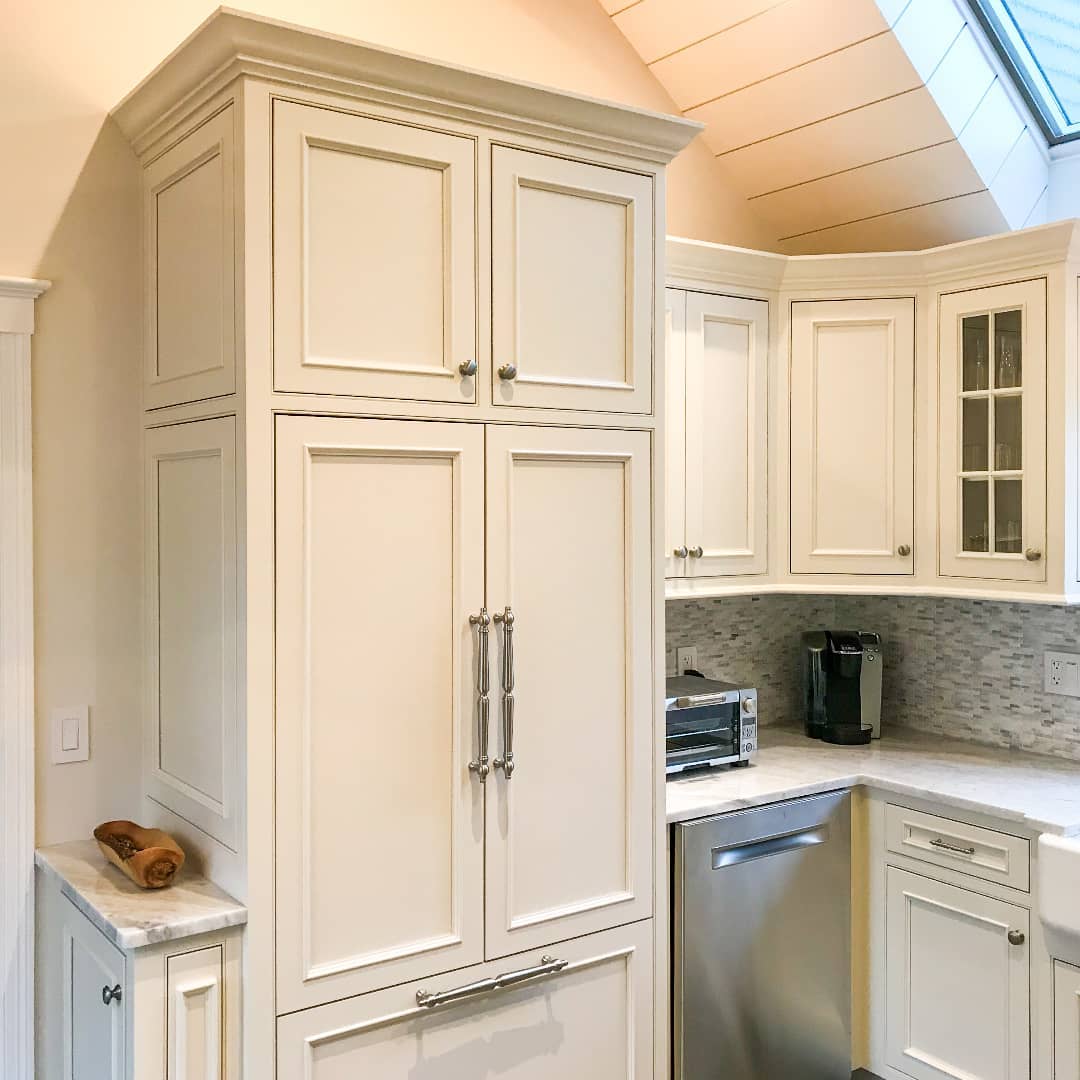 A panel ready refrigerator integrated seamlessly into the custom cabinetry of an elegant, well-lit kitchen.